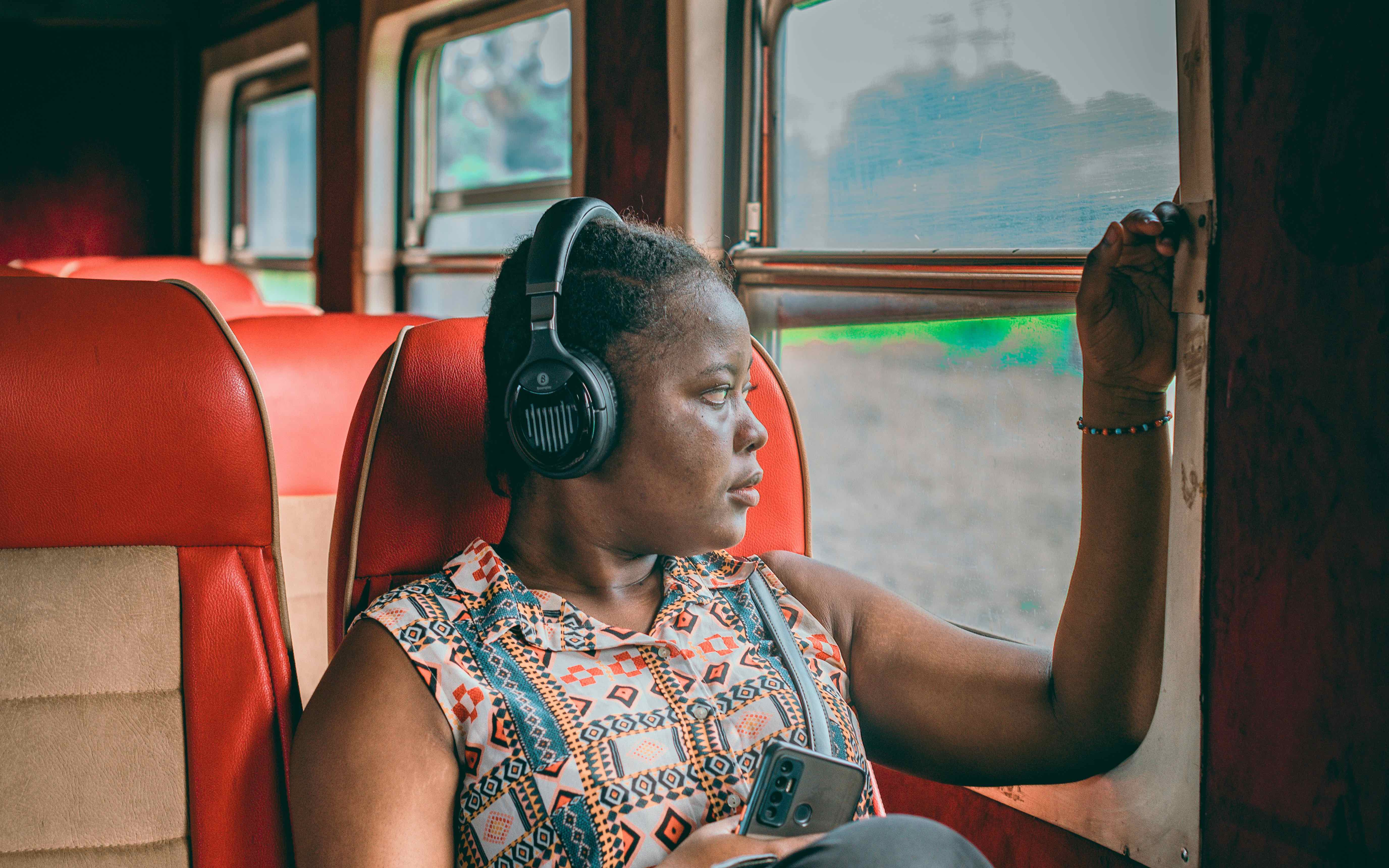 Person wearing headphones while commuting on train